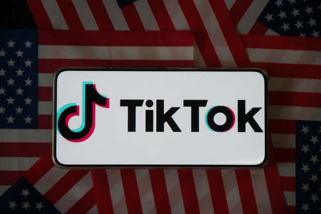 Photo illustration of the TikTok logo displayed on a phone on top of a circle of U.S. flags.