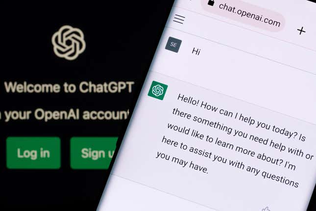 ChatGPT chatbot seen on a smartphone screen with ChatGPT login on laptop screen in background