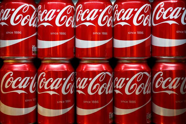 Two stacked rows of classic red Coca-Cola cans.