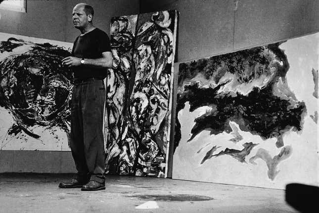 American abstract expressionist painter Jackson Pollock (1912 - 1956) stands amid some large paintings in his studio at ‘The Springs,’ East Hampton, New York, August 23, 1953. Number 17A not pictured.